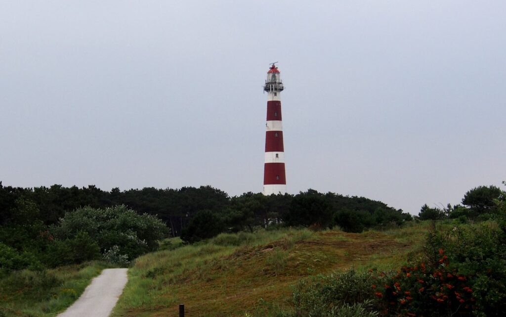 Rot-weiß gestreifter Leuchtturm Bornrif bei Hollum über den Dünen von Ameland