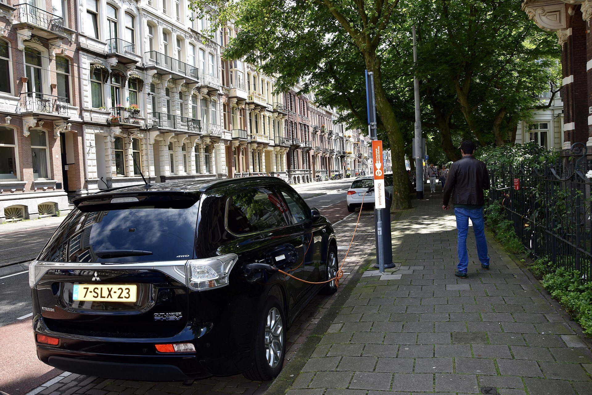 Elektroauto an einer öffentlichen Ladesäule am Straßenrand in einer niederländischen Stadt