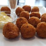 Bitterballen: Ein kulinarisches Nationalheiligtum Knusprige Bitterballen mit Senf auf einem weißen Teller