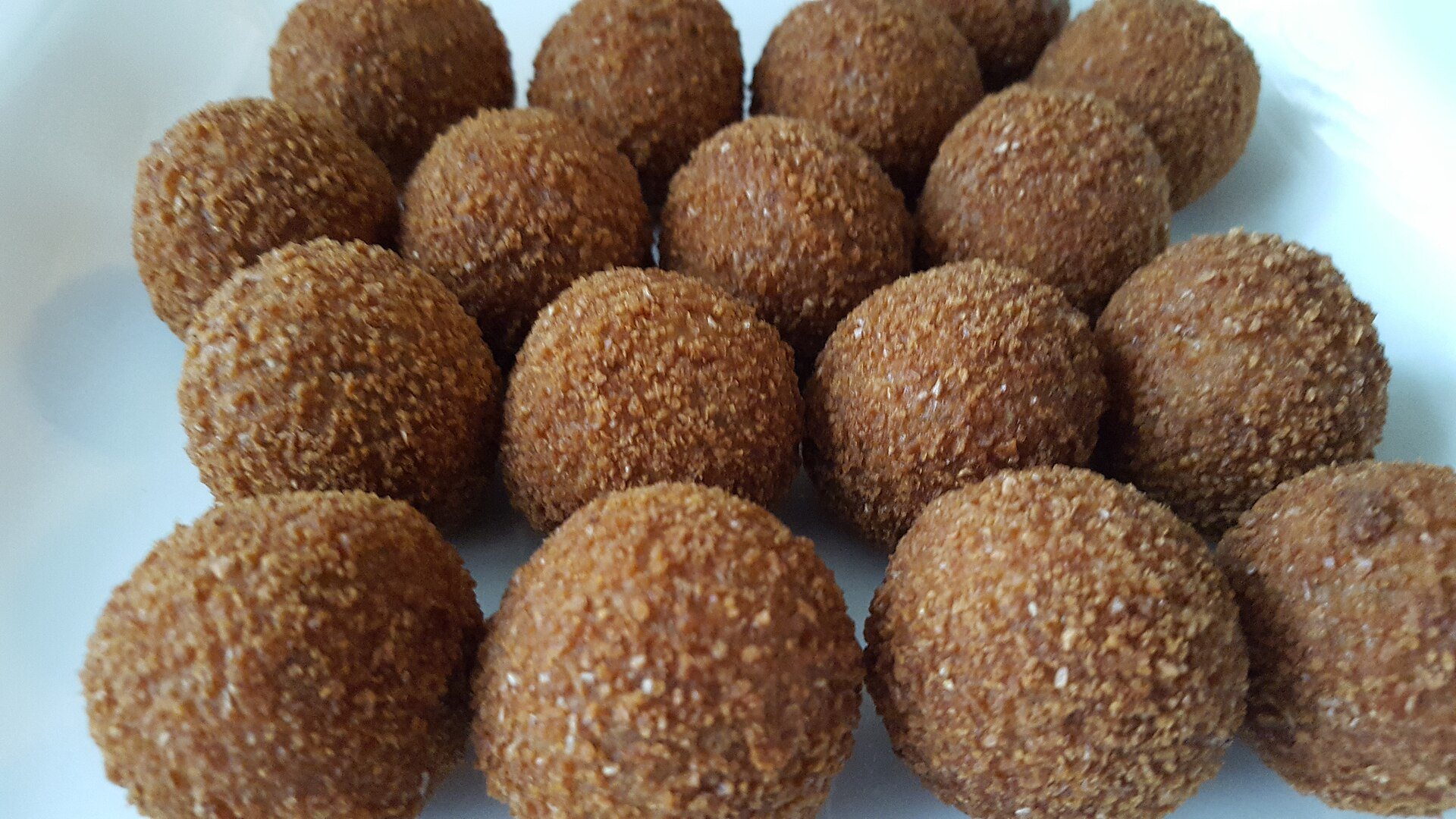 Nahaufnahme goldbraun panierter Bitterballen mit Semmelbröselkruste