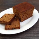 Ontbijtkoek: Der holländische Frühstückskuchen – mehr als nur Frühstück Angeschnittener niederländischer Ontbijtkoek mit Scheiben auf einem Teller