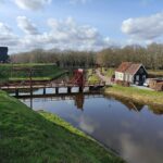 Die Festungsstadt Bourtange: Ein Besuch in der Zeitmaschine Holzbrücke über den Festungsgraben von Bourtange mit Wall und Bockwindmühle