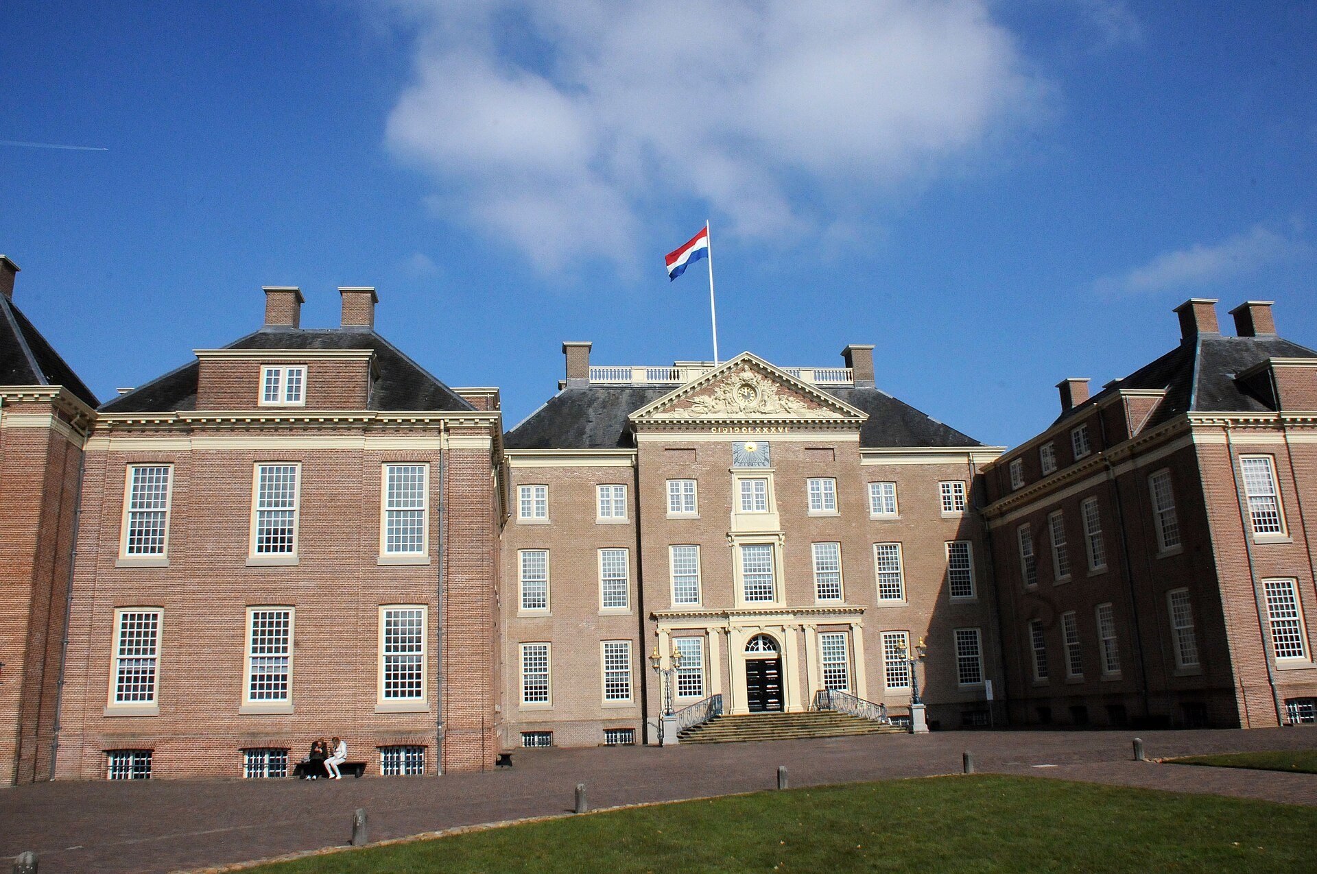 Hauptfassade von Paleis Het Loo in Apeldoorn mit niederländischer Flagge