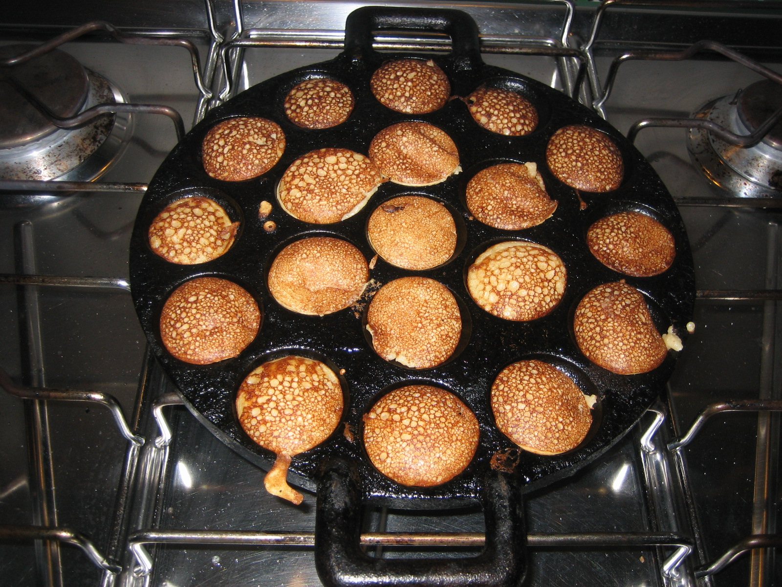 Gusseiserne Poffertjespfanne mit frisch gebackenen Poffertjes