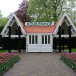 Barrierefrei reisen in den Niederlanden: Ein Leitfaden für zugängliche Urlaube Eingangspavillon des Keukenhof mit gepflastertem Weg und blühenden Tulpenbeeten