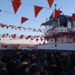 Feiertage und Feste in den Niederlanden: Was Sie wissen müssen Orangefarbene Wimpel und feiernde Menschen am Koningsdag in Amsterdam