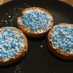 Beschuit met Muisjes: Tradition zur Geburt eines Kindes Beschuit mit Butter und blauen Muisjes auf einem Teller zur Geburt eines Jungen