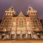 Die Museumkaart: Lohnt sich die Jahreskarte für Touristen? Beleuchtete Hauptfassade des Rijksmuseums in Amsterdam am Abend
