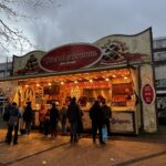 Oliebollen zu Silvester: Tradition und Rezept Oliebollenkraam im Dezember mit wartenden Kunden in Voorburg