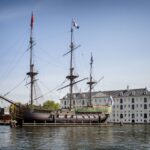 Die Geschichte der Niederländischen Ostindien-Kompanie (VOC) Nachbau des VOC-Schiffs Amsterdam vor dem Scheepvaartmuseum in Amsterdam