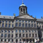 Das niederländische Königshaus: Tradition & Moderne Königlicher Palast auf dem Dam in Amsterdam bei klarem Himmel