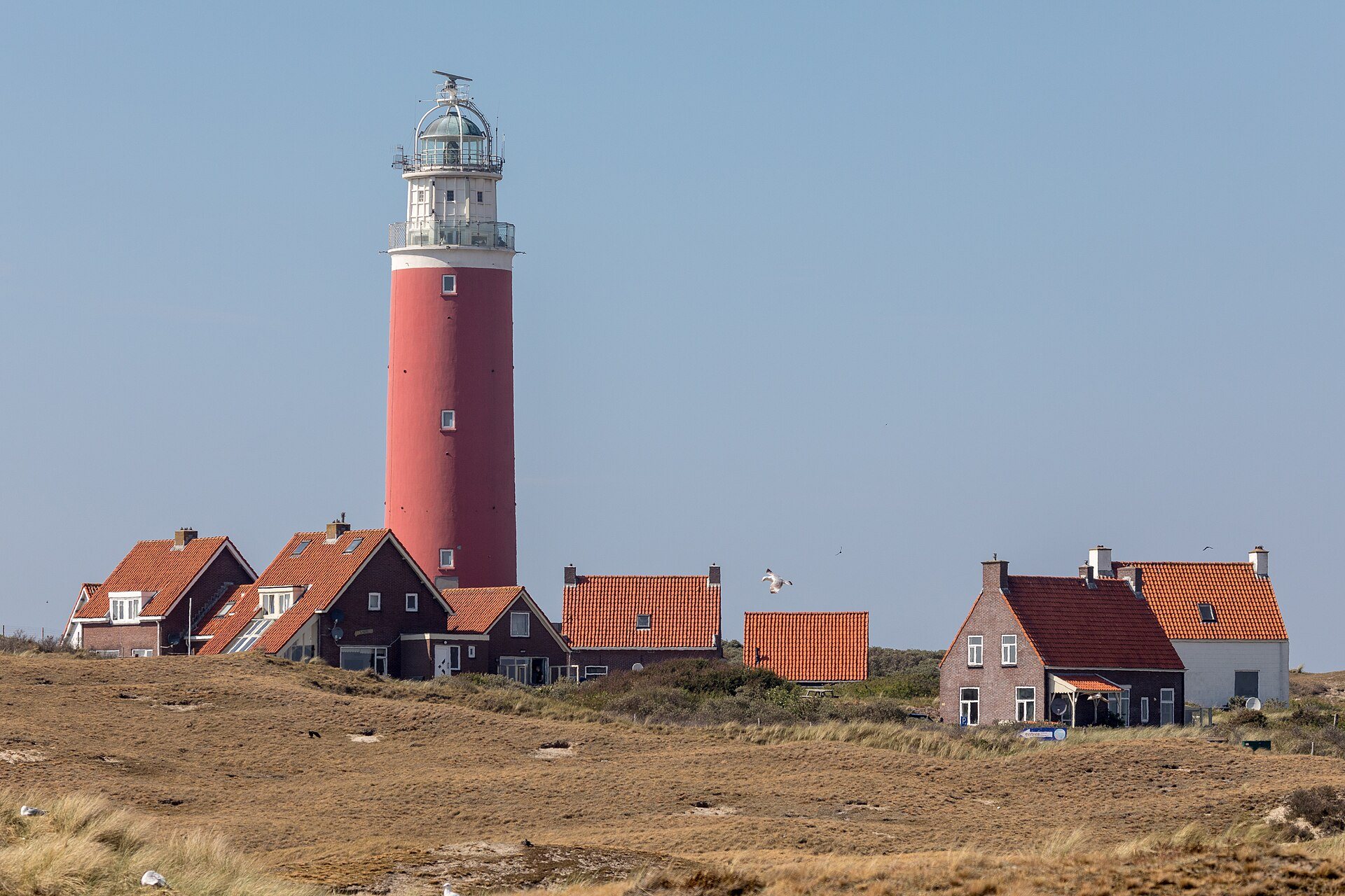 Roter Leuchtturm Eierland mit Häusern bei De Cocksdorp auf Texel
