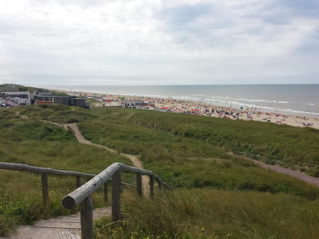 Dünenweg mit Holzgeländer hinunter zum Strand von Egmond aan Zee