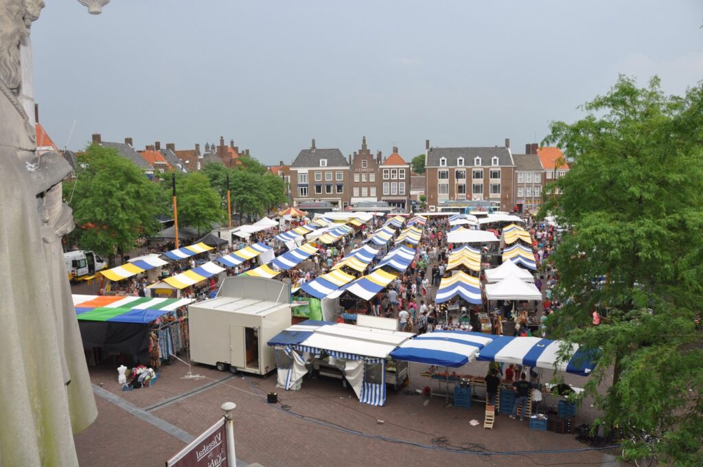 Wochenmarkt mit blau-weißen Marktständen auf dem Markt in Middelburg