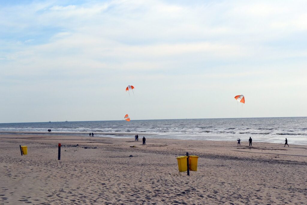 Breiter Nordseestrand bei Langevelderslag in Noordwijk mit Lenkdrachen am Himmel