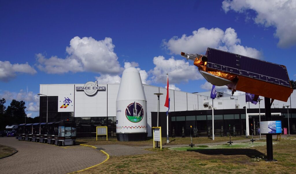 Eingang der Space Expo in Noordwijk mit Raketenspitze und Satellitenmodell