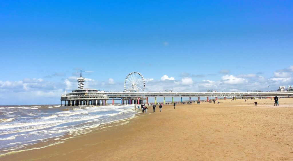 Breiter Sandstrand von Scheveningen mit dem Pier und seinem Riesenrad im Hintergrund