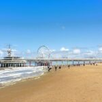 Scheveningen: Strandabschnitte, Parken, Hunde und Anreise Breiter Sandstrand von Scheveningen mit dem Pier und seinem Riesenrad im Hintergrund