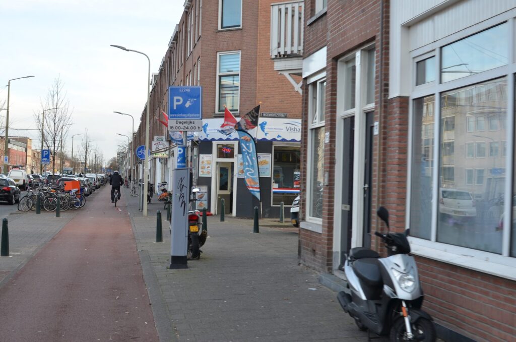 Parkautomat und Parkzonenschild an einer Wohnstraße in Den Haag