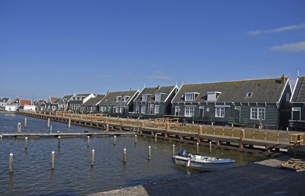 Grüne Holzhäuser auf Pfählen an der Havenbuurt in Marken am Wasser