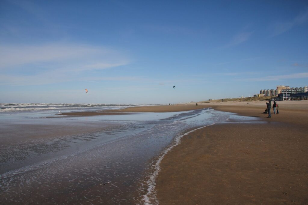 Weiter Sandstrand von Zandvoort bei Ebbe mit Prielen und blauem Himmel